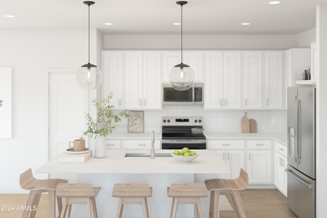 kitchen with decorative light fixtures, sink, white cabinetry, and stainless steel appliances