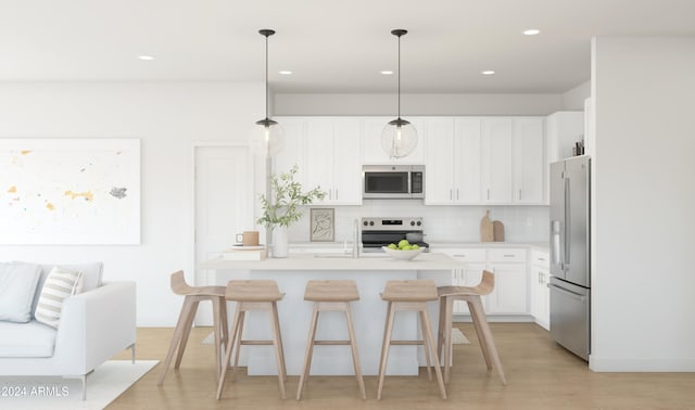 kitchen featuring hanging light fixtures, light wood-type flooring, appliances with stainless steel finishes, tasteful backsplash, and white cabinetry