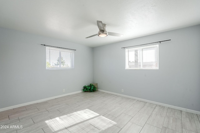 spare room featuring ceiling fan and plenty of natural light