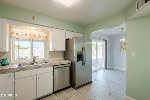 kitchen featuring tasteful backsplash, sink, white cabinets, and appliances with stainless steel finishes