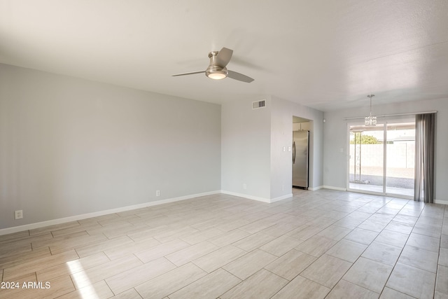 unfurnished room featuring ceiling fan with notable chandelier