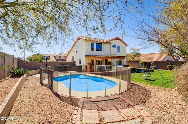 view of swimming pool featuring a playground, a patio, and a lawn