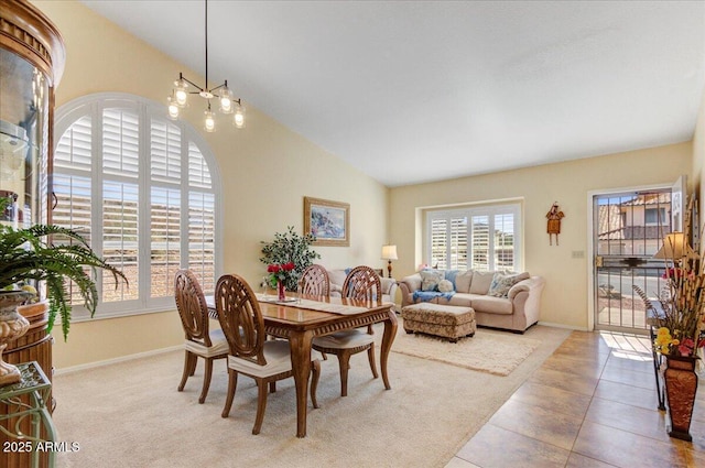 carpeted dining area with vaulted ceiling and a chandelier