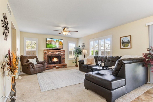 living room featuring ceiling fan, light carpet, a brick fireplace, and plenty of natural light