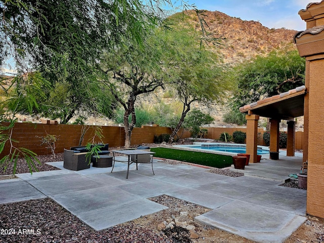 view of patio featuring a fenced in pool and a mountain view