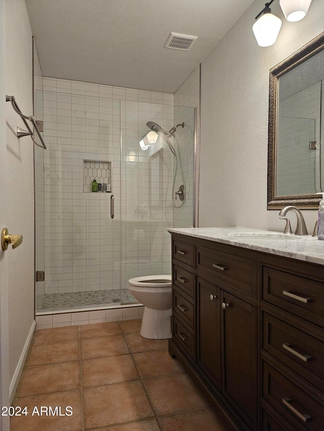 bathroom with a shower with door, tile patterned flooring, a textured ceiling, vanity, and toilet