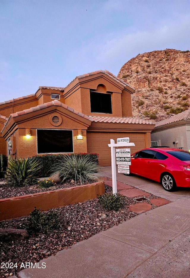 view of front of home with a garage and a mountain view