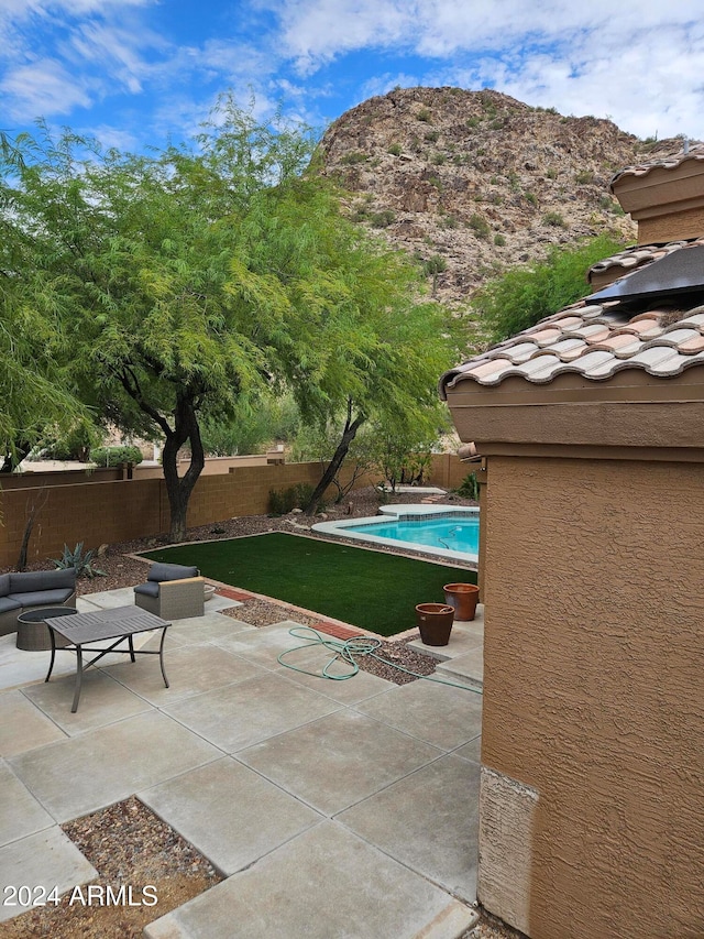 view of swimming pool with a patio and a mountain view