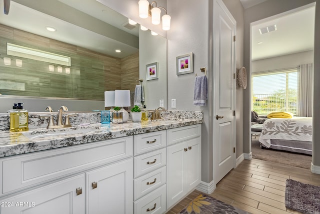 bathroom featuring wood-type flooring, oversized vanity, and double sink