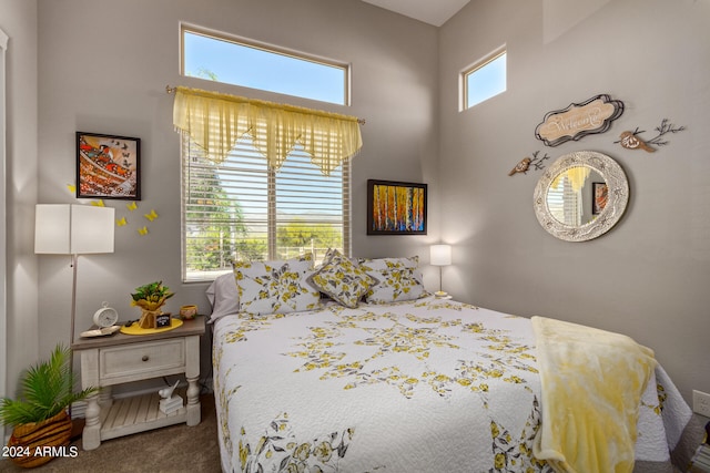 carpeted bedroom with multiple windows and a towering ceiling