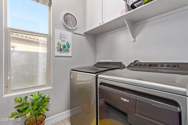 laundry room featuring a healthy amount of sunlight, hardwood / wood-style flooring, and washer and clothes dryer