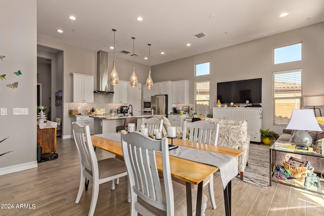 dining area with plenty of natural light, sink, and light wood-type flooring