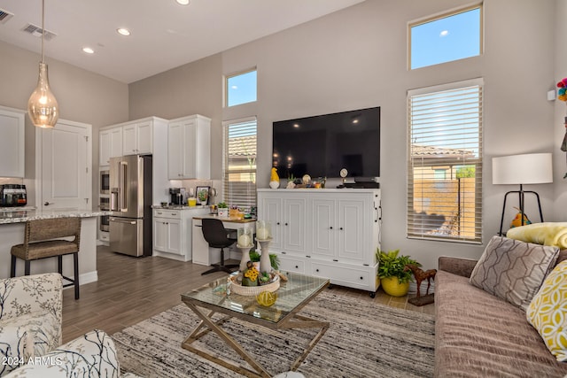 living room with dark hardwood / wood-style floors and a high ceiling