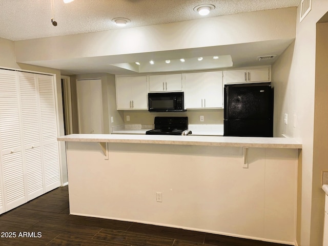 1920 W Lindner Ave Unit 137, Mesa, AZ 85202 - kitchen featuring black appliances, light countertops, dark wood-type flooring, a kitchen bar, and a textured ceiling