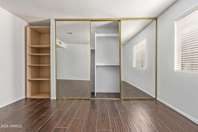 unfurnished bedroom with a closet, multiple windows, and a textured ceiling