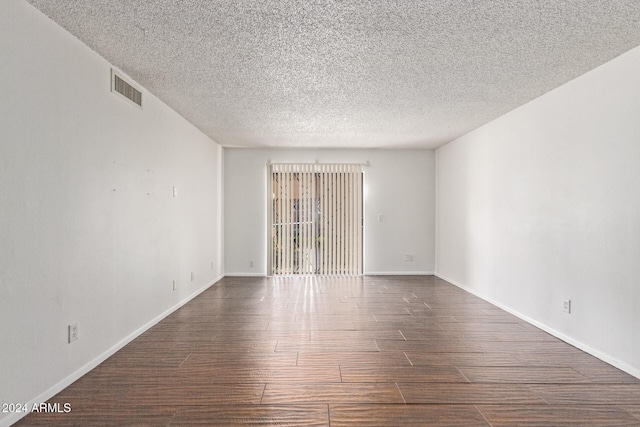 unfurnished room with a textured ceiling