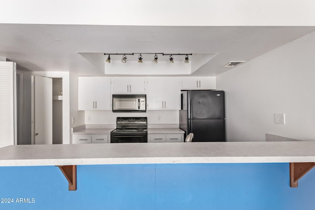 kitchen with rail lighting, white cabinetry, black appliances, and kitchen peninsula