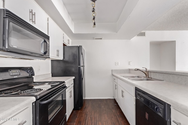 kitchen with sink, white cabinets, rail lighting, black appliances, and dark wood-type flooring