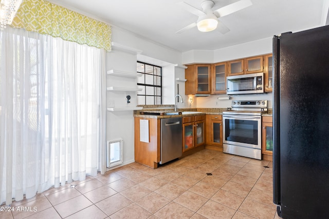 kitchen featuring ceiling fan, stainless steel appliances, light tile patterned floors, and a wealth of natural light