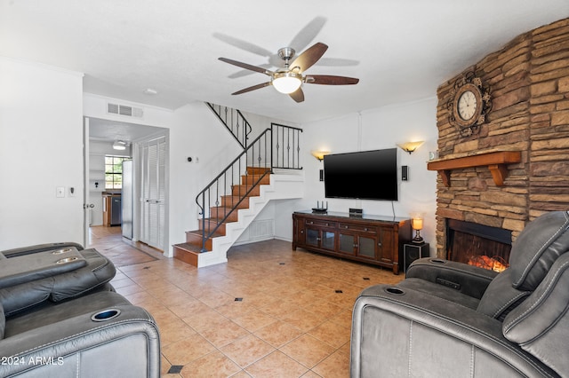 tiled living room with a fireplace and ceiling fan