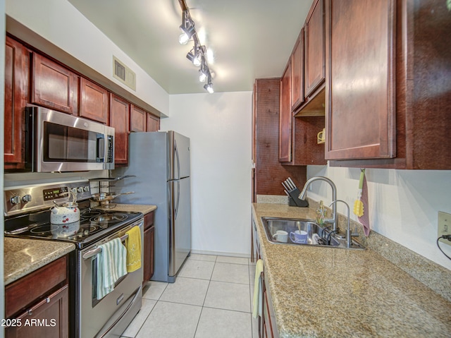 3600 N Hayden Rd Unit 2310, Scottsdale, AZ 85251 - kitchen with stainless steel appliances, a sink, reddish brown cabinets, light tile patterned floors, and decorative backsplash