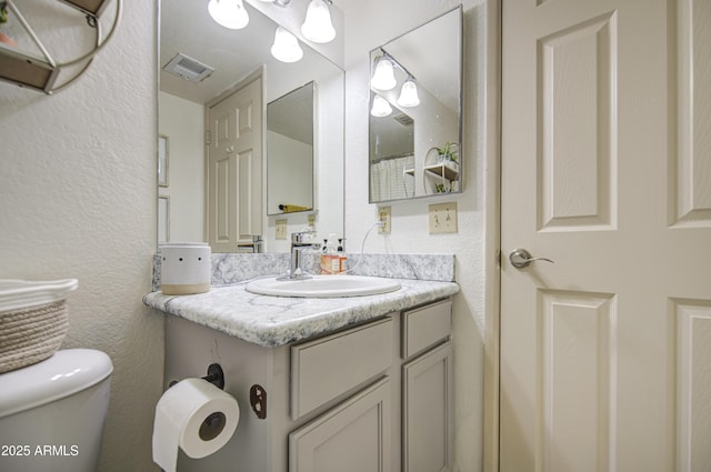 3600 N Hayden Rd Unit 2310, Scottsdale, AZ 85251 - half bathroom featuring toilet, vanity, and a textured wall