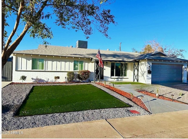 ranch-style house featuring board and batten siding, an attached garage, driveway, and a front lawn