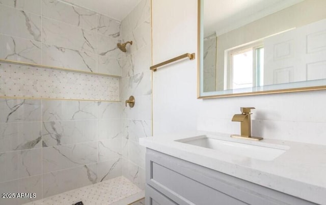 bathroom featuring tiled shower and vanity