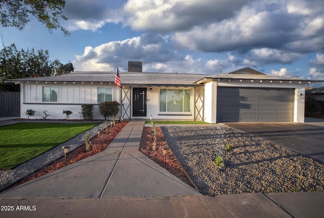 single story home with a garage, brick siding, driveway, and a front lawn