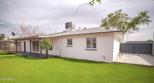 back of house featuring cooling unit, a patio area, and a yard