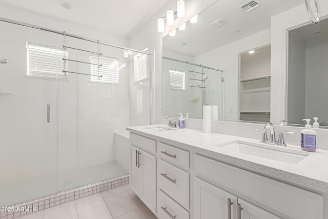 bathroom with tile patterned flooring, vanity, and a shower with shower door