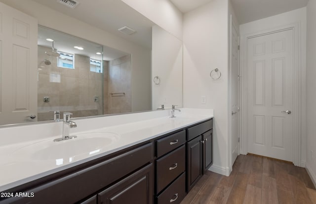 bathroom featuring vanity, wood-type flooring, and a shower with shower door