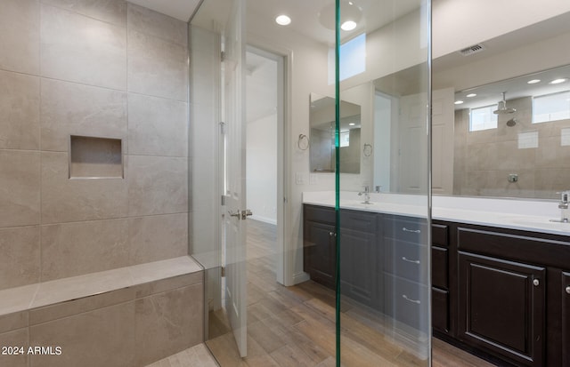 bathroom featuring vanity, hardwood / wood-style floors, and a tile shower