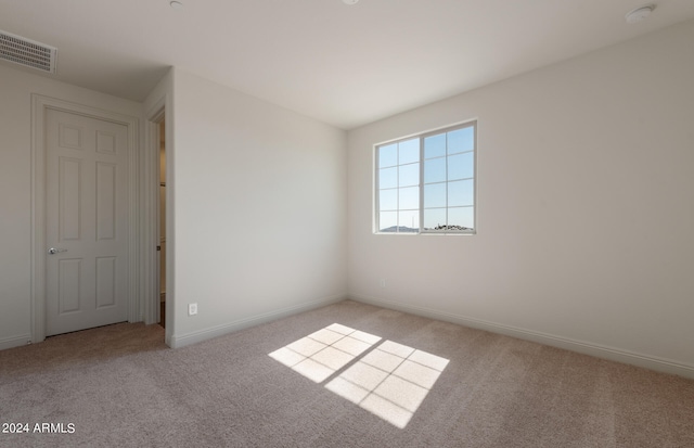 spare room featuring light colored carpet