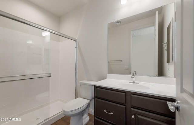 bathroom featuring toilet, walk in shower, vanity, and hardwood / wood-style flooring