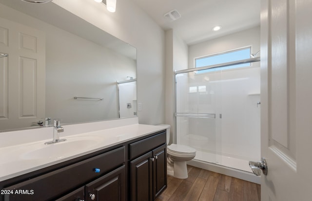 bathroom with toilet, walk in shower, vanity, and hardwood / wood-style flooring