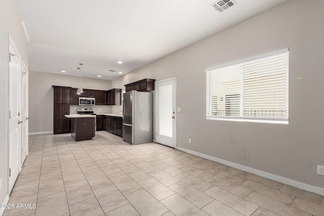 2000 N 36th St Unit 19, Phoenix, AZ 85008 - kitchen with stainless steel appliances, a kitchen island, dark brown cabinets, light countertops, and light tile patterned floors