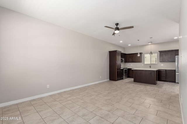 2000 N 36th St Unit 19, Phoenix, AZ 85008 - kitchen with stainless steel appliances, ceiling fan, light countertops, dark brown cabinets, and a center island