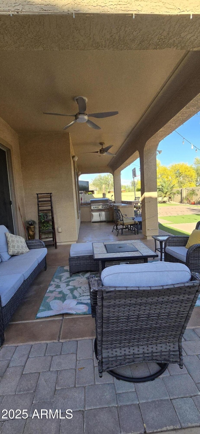 view of patio / terrace with exterior kitchen, outdoor lounge area, a ceiling fan, and area for grilling