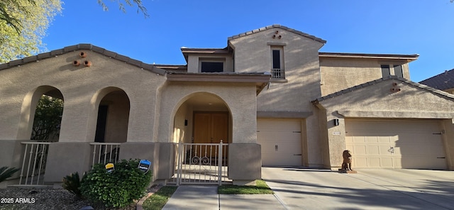 mediterranean / spanish-style home featuring a tiled roof, driveway, a gate, and stucco siding