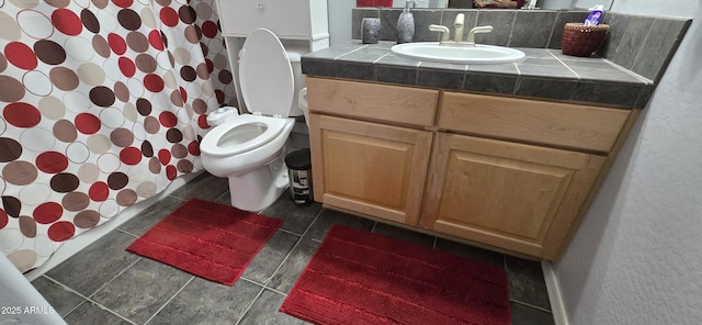 bathroom featuring toilet, tile patterned floors, vanity, and curtained shower