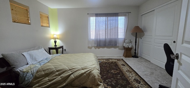 carpeted bedroom featuring baseboards and a closet