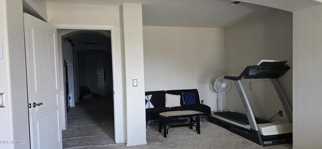 workout room with arched walkways, baseboards, and carpet