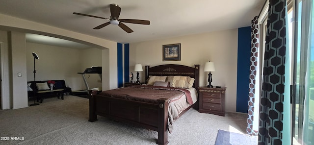 bedroom with arched walkways, a ceiling fan, and light colored carpet