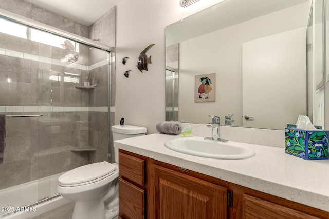 bathroom featuring a stall shower, vanity, and toilet