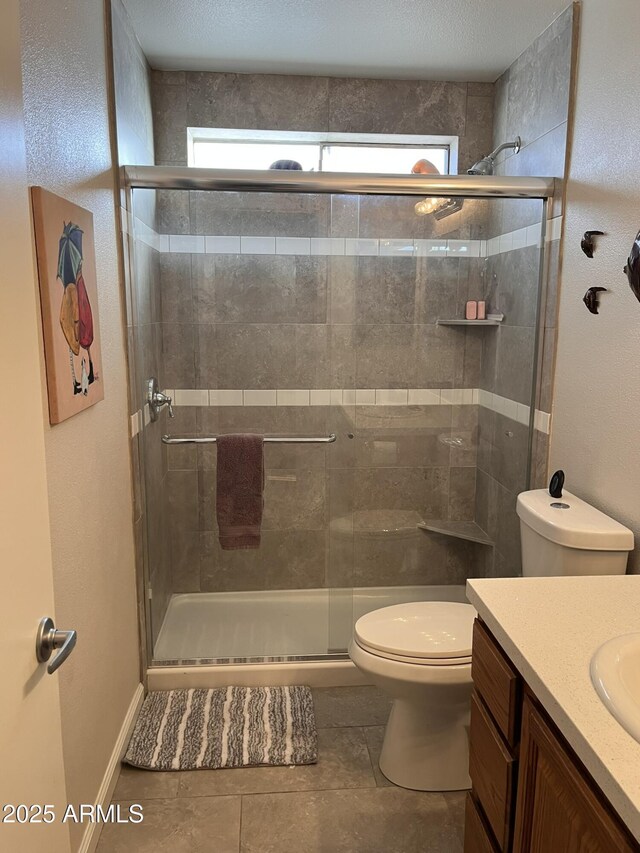 full bathroom featuring vanity, a shower stall, and toilet