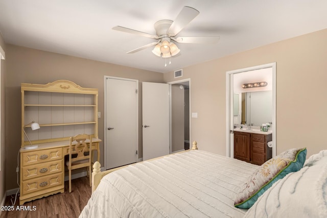 bedroom featuring visible vents, connected bathroom, ceiling fan, dark wood-style flooring, and a sink