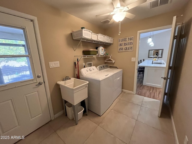 laundry area featuring laundry area, light tile patterned floors, visible vents, washer and dryer, and a sink