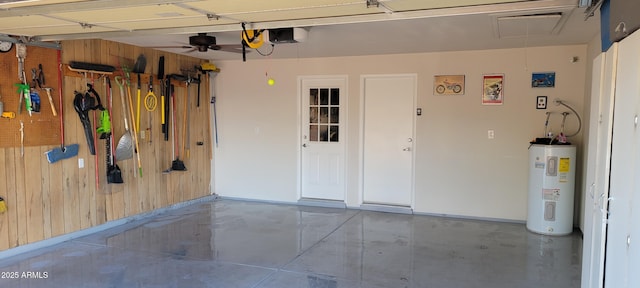 garage featuring a garage door opener, water heater, and wooden walls