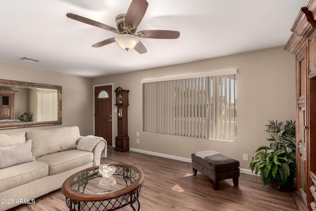 living area featuring ceiling fan, wood finished floors, visible vents, and baseboards